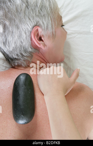 Young woman getting massage aux pierres chaudes. Banque D'Images