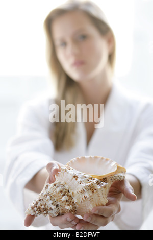 Young woman holding seashell. Banque D'Images