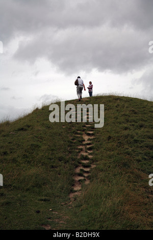 Les promeneurs sur le cercle de pierres debout préhistorique à Avebury, Wiltshire, Royaume-Uni - un site du patrimoine mondial Banque D'Images