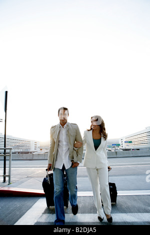 Jeune couple arrivant à l'aéroport avec des bagages. Banque D'Images