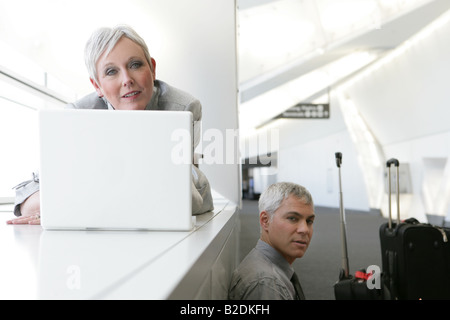 D'âge mûr en attente dans l'aéroport avec ordinateur portable. Banque D'Images