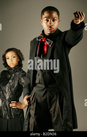 Young African American man avec fist, femme derrière. Banque D'Images