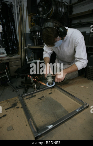 Asian man welding en entrepôt. Banque D'Images