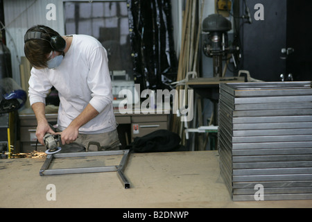 Asian man welding en entrepôt. Banque D'Images