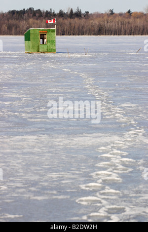 Chemin froid gelé : footprints faire un sentier sinueux sur un green cabane de pêche sur la glace au milieu de la rivière Banque D'Images