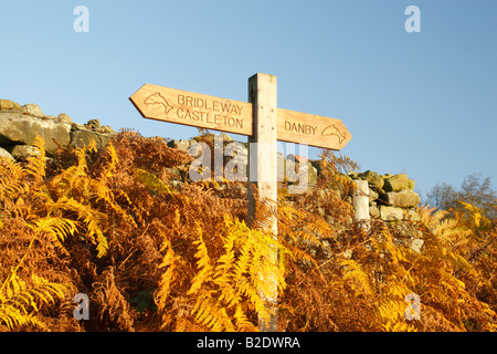Bridleway signe sur l'Esk Valley à pied route entre Castleton et Danby contre un mur de pierre et d'or de la fougère avec un ciel bleu Banque D'Images