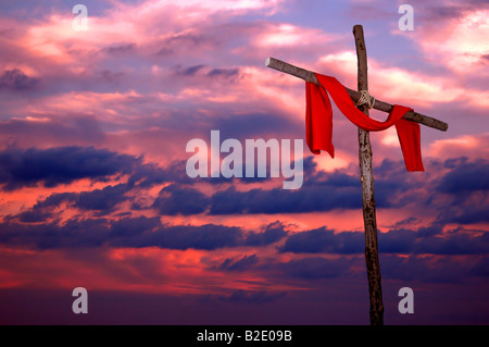 Croix et tunique rouge sur un coucher de soleil colorés Banque D'Images