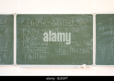 Des formules mathématiques écrites sur le desk in classroom Banque D'Images