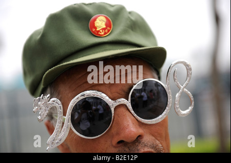 Ventilateur chinois avec Mao de badge et lunettes l'élaboration de 2008 et à l'extérieur du dragon vert olympique à Beijing. 27-JUIL-2008 Banque D'Images