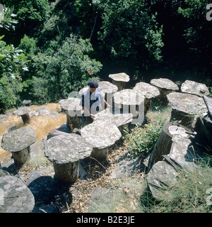 L'apiculteur inspecte les ruches construites avec chestnut tree trunk et surmontées de lauze Ardèche France Banque D'Images