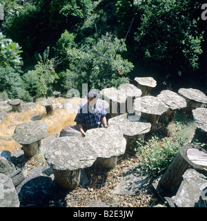 L'apiculteur inspecte les ruches construites avec chestnut tree trunk et surmontées de lauze Ardèche France Banque D'Images