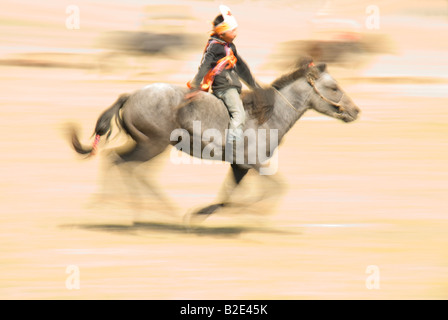 Jeune garçon mongol rides bareback dans une course de chevaux à un Naadum Festival à Renchinlhumbe en Mongolie extérieure Banque D'Images