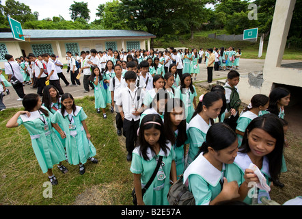 Les élèves des écoles secondaires catholiques Mansalay chef à leurs classes à Mansalay, Mindoro oriental, Philippines. Banque D'Images