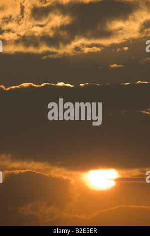 Coucher de soleil derrière les nuages Banque D'Images