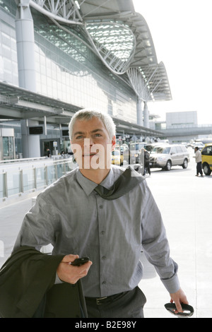 Mature businessman pulling suitcase à l'aéroport. Banque D'Images