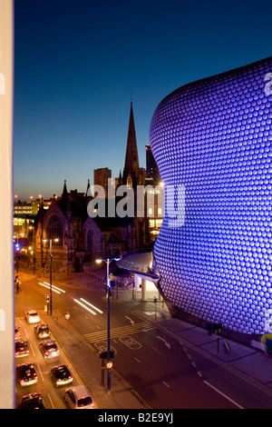 Allumé en bâtiment avec en arrière-plan la nuit Selfridges Building St Martins Church Birmingham England Banque D'Images