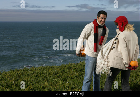 Jeune couple à l'autre holding pumpkins derrière le dos. Banque D'Images