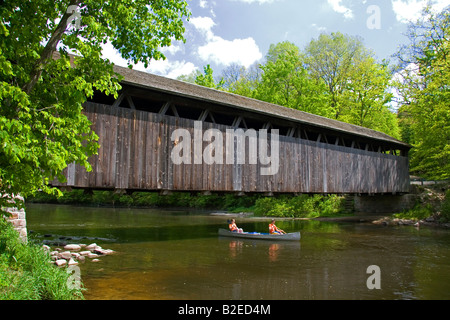 Canoe qui passe sous le pont de blancs sur la rivière Flat à Keene Township au Michigan Banque D'Images