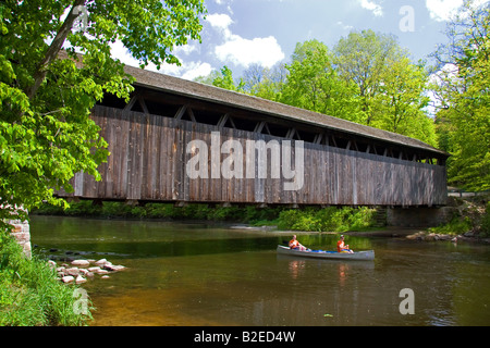 Canoe qui passe sous le pont de blancs sur la rivière Flat à Keene Township au Michigan Banque D'Images