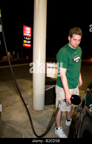 Prix de l'essence affiché derrière un homme pompiste à Lansing Michigan le 31 mai 2008 Banque D'Images