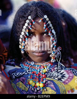 Loin d'une fille a sa coiffure attrayante orné de boutons et de perles, ce qui est typique des jeunes filles de sa tribu. Banque D'Images