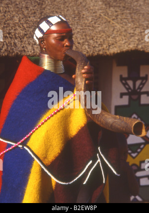 Ndebele Woman in traditional dress blowing sur corne de koudou Banque D'Images