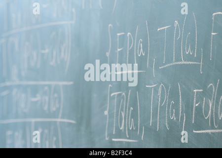 Des formules mathématiques écrites sur le desk in classroom Banque D'Images