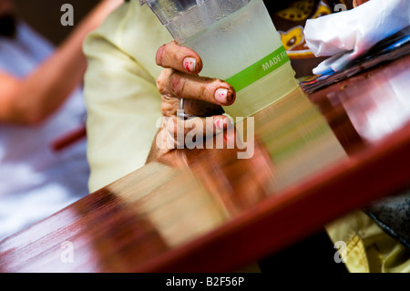 Tenir la main de femme vieille tasse de limonade sur la table de café Banque D'Images