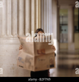 Girl reading Financial Times Banque D'Images