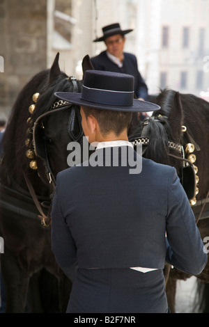 Espagne Toledo jeune accompagnateur stand by chevaux avec transport et deux chevaux noirs costume et chapeau Banque D'Images