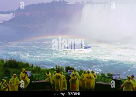 Les touristes à la partie inférieure de la plate-forme d'observation observation Journey Behind the Falls Niagara Falls avec rainbow et Maid of Mist Banque D'Images