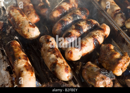 La cuisson sur un barbecue saucisses Banque D'Images