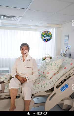 Portrait d'une femme assise avec les mains jointes dans l'hôpital Banque D'Images