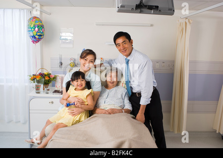 Portrait d'une femme couchée sur le lit et souriant avec sa famille Banque D'Images