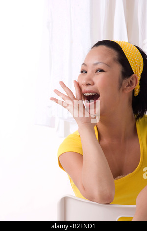 Portrait d'un jeune homme assis sur une chaise et crier Banque D'Images