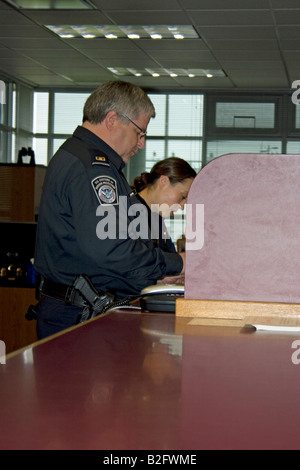 Questions et d'agents des services frontaliers ou inspecte un entrant dans le port d'entrée américain Washington de Sumas. Banque D'Images