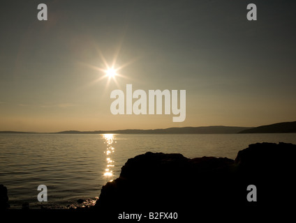 Le coucher de soleil sur les rochers de la baie de Morecambe à Silverdale, Lancashire, Angleterre Banque D'Images