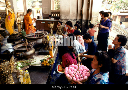 Temple bouddhiste auprès des gens de l'offrant de la nourriture, Bangkok, Thaïlande Banque D'Images