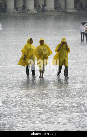 Trois touristes dans de fortes pluies à St Peters Square, Rome Banque D'Images