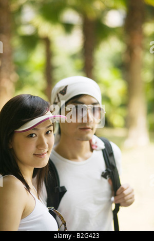 Portrait of a young woman smiling avec un jeune homme portant un sac Banque D'Images