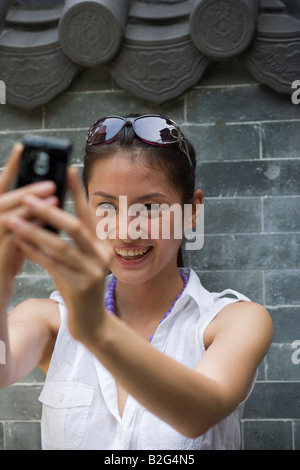 Jeune femme photographier avec un téléphone appareil photo Banque D'Images