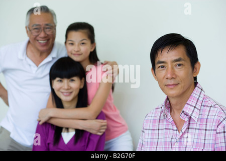 Portrait of a Mid adult man smiling avec sa famille dans l'arrière-plan Banque D'Images