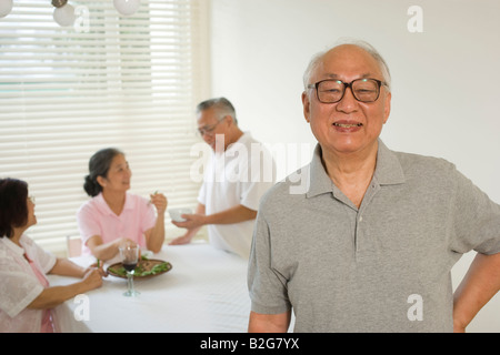 Close-up of a senior man smiling avec ses amis dans l'arrière-plan Banque D'Images