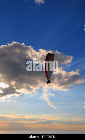 Un parapentiste vole dans le coucher de soleil sur Heacham plage sur la côte de Norfolk, Angleterre, Royaume-Uni. Banque D'Images