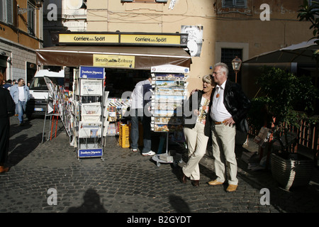 Couple standing par kiosque situé dans le Trastevere, Rome Banque D'Images