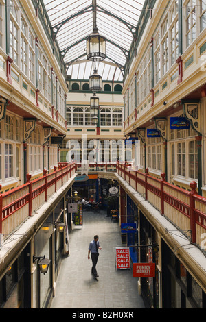 Un homme marche à travers le centre-ville de Cardiff Castle Arcade Banque D'Images