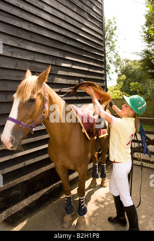 Levage de fille à cheval sur la selle Banque D'Images