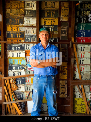 Agriculteur de garage en face de l'ensemble de ses familles liscence les plaques de l 1920 s Banque D'Images