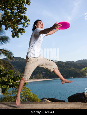 Jeune homme jouant avec un disque en plastique, Phuket, Thailand Banque D'Images