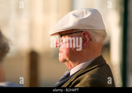 Old man wearing flat cap blanc et spectacles soirée d'été dans le profil UK Banque D'Images